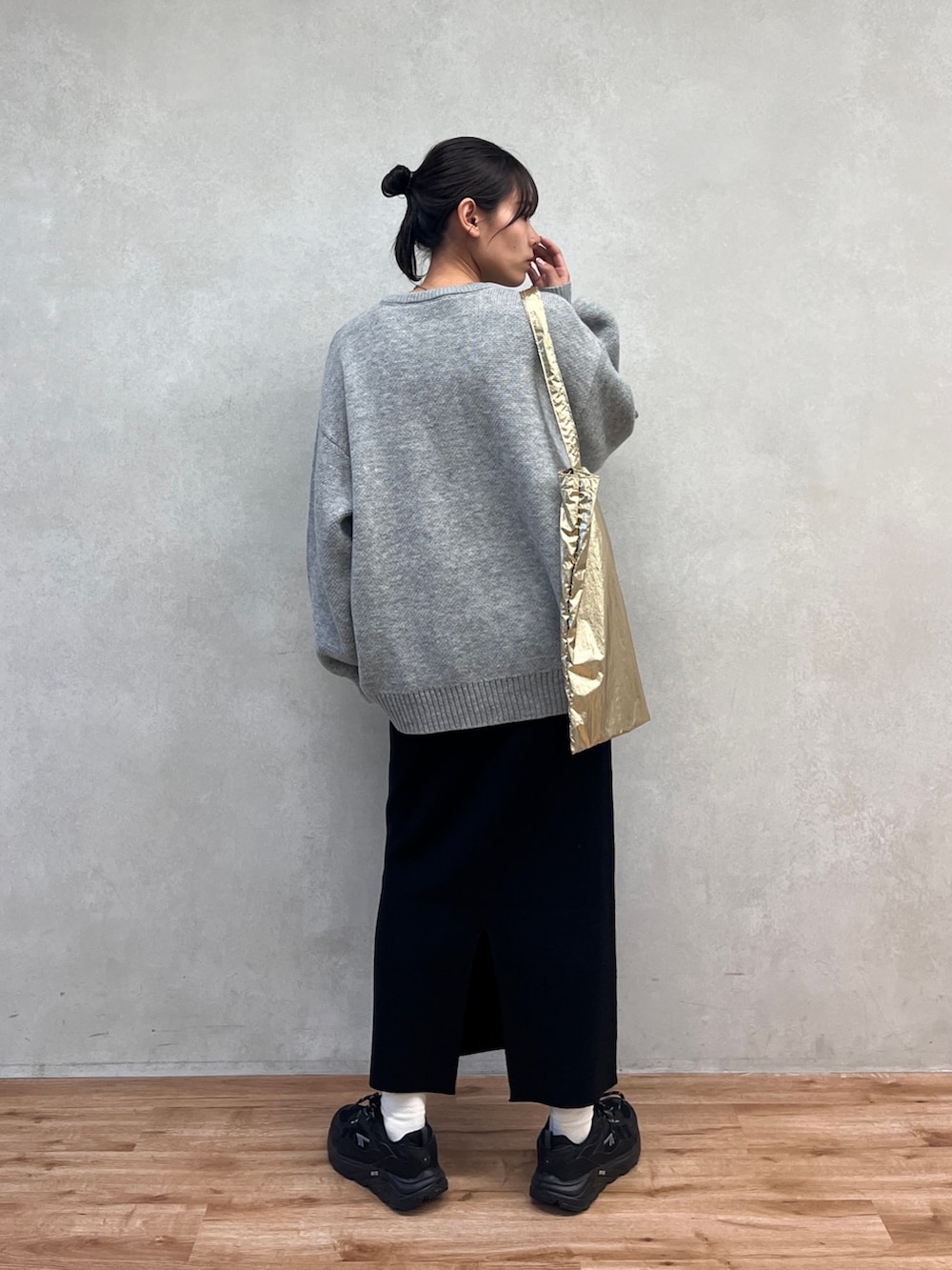 グレー系のニット/セーター、ブラック系のスカートを着用したレディースの冬コーディネートの3枚目の写真