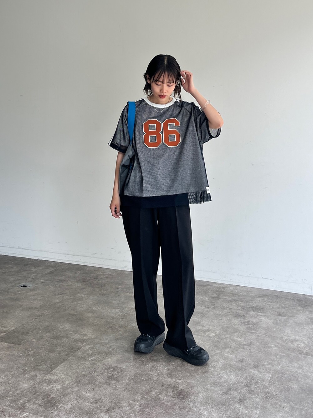 ブルー系のTシャツ/カットソー、ブラック系のスラックスを着用したレディースの夏コーディネートの2枚目の写真