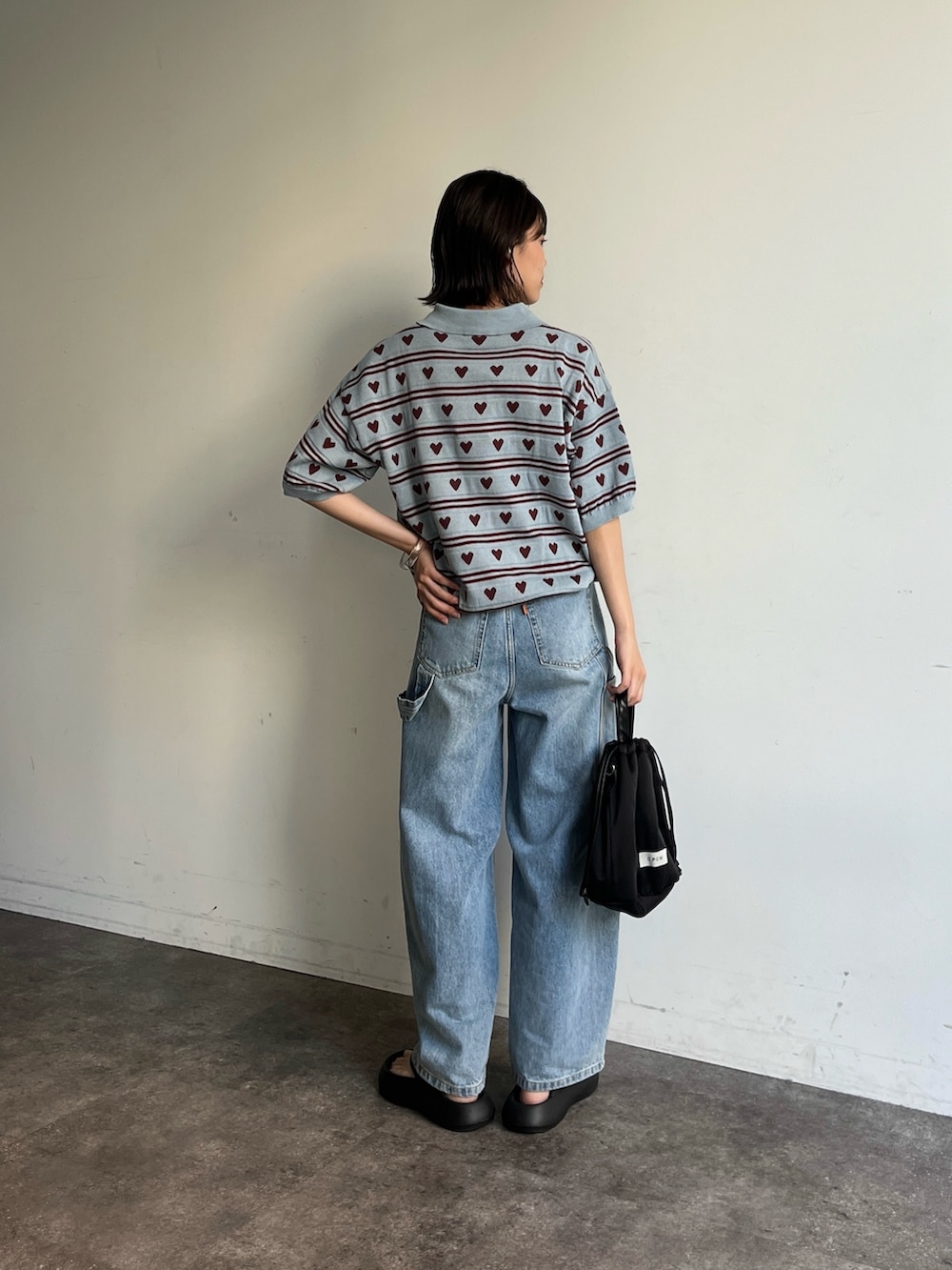 ブルー系のニット/セーター、ブルー系のデニムパンツ、ブラック系のサンダルを着用したレディースの夏コーディネートの3枚目の写真