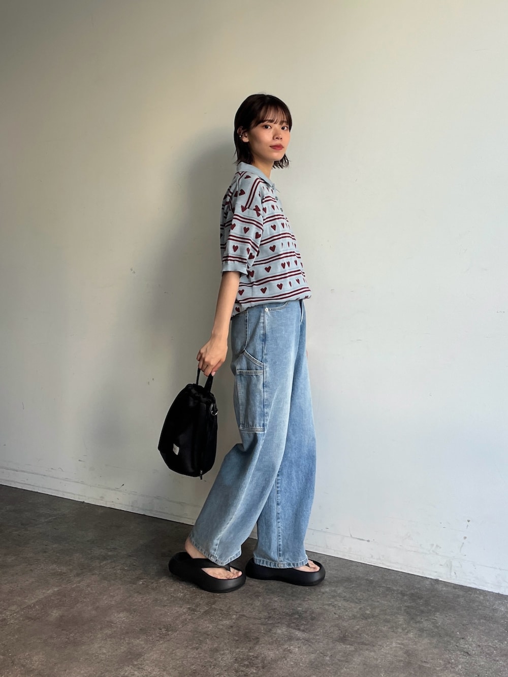 ブルー系のニット/セーター、ブルー系のデニムパンツ、ブラック系のサンダルを着用したレディースの夏コーディネートの2枚目の写真