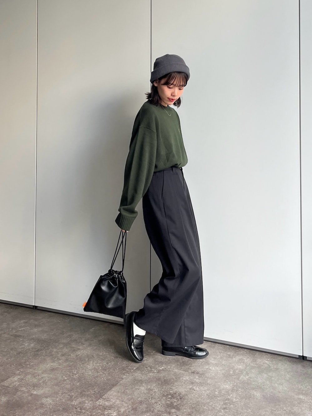 グリーン系のニット/セーター、ブラック系のその他パンツを着用したレディースの秋コーディネートの3枚目の写真