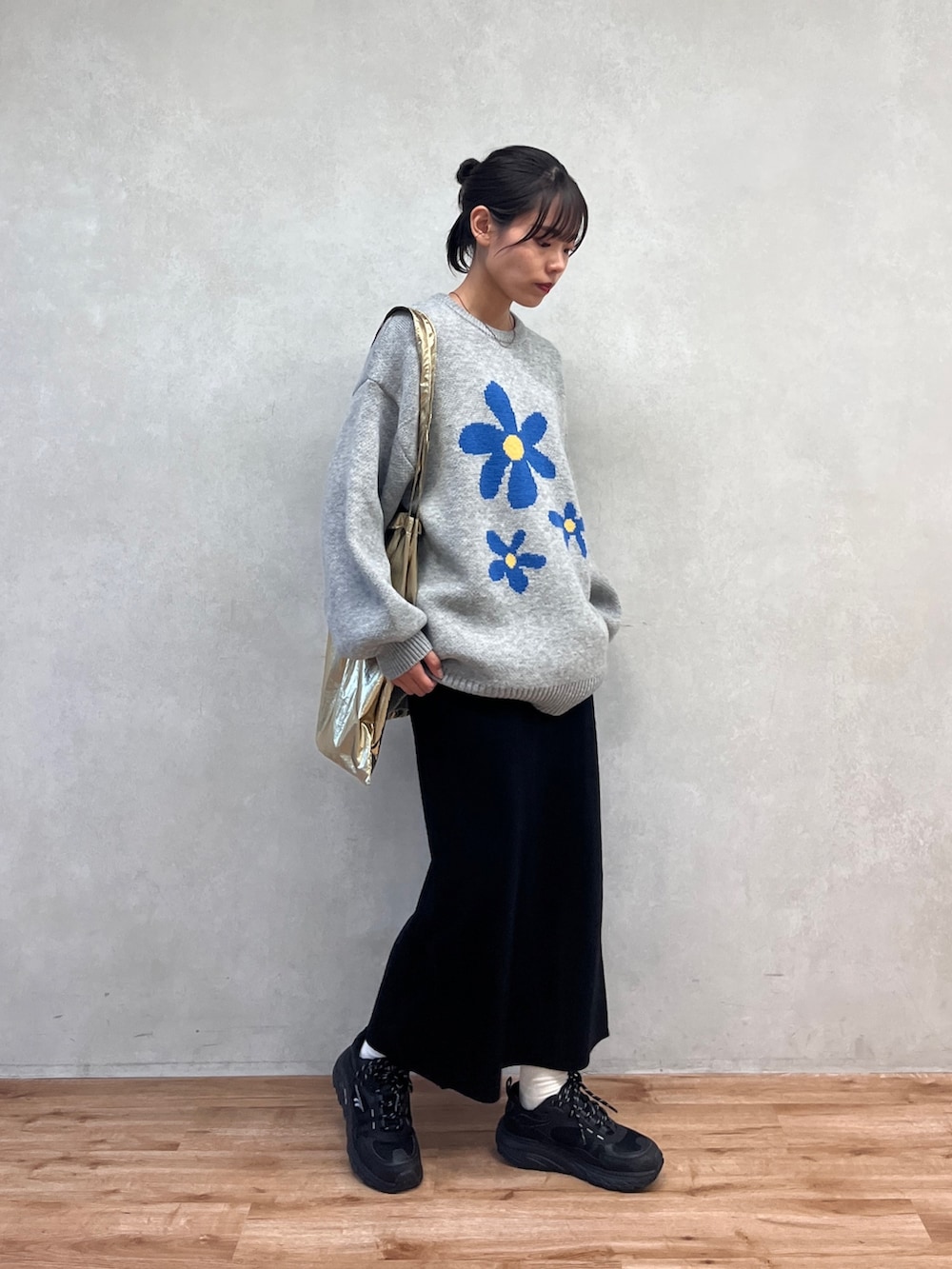 グレー系のニット/セーター、ブラック系のスカートを着用したレディースの冬コーディネートの2枚目の写真