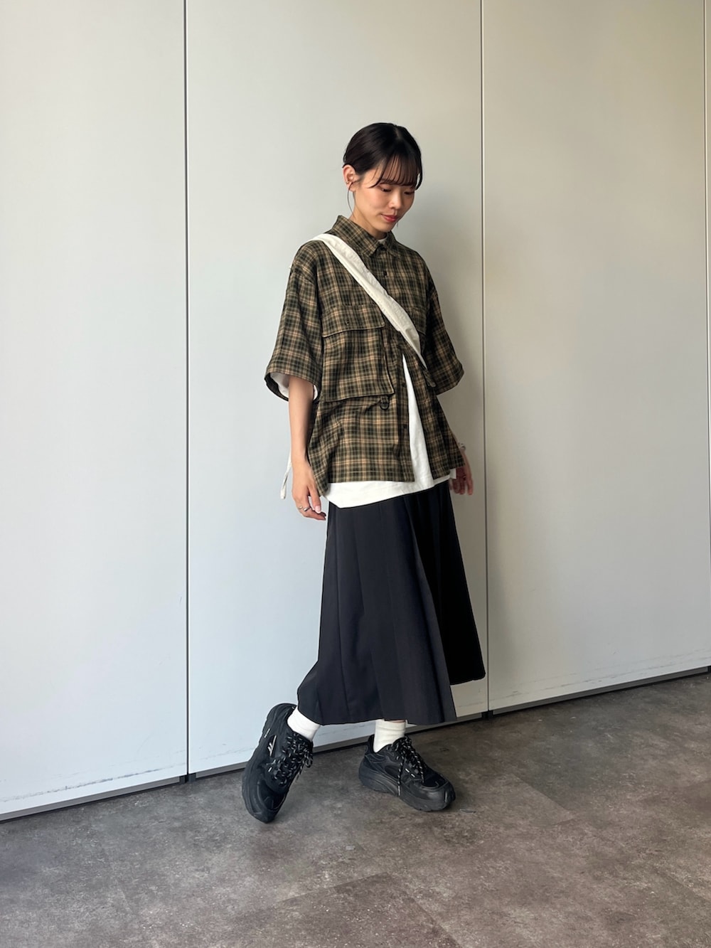 グリーン系のシャツ/ブラウス、ブラック系のスカートを着用したレディースの夏コーディネートの3枚目の写真