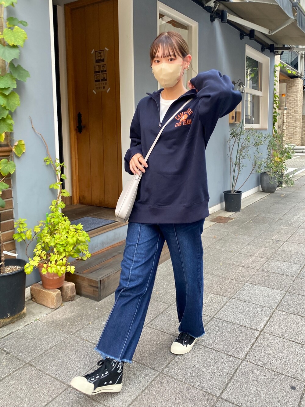 ブルー系のスウェット、ブルー系のデニムパンツ、ブラック系のスニーカーを着用したレディースの秋コーディネートの2枚目の写真