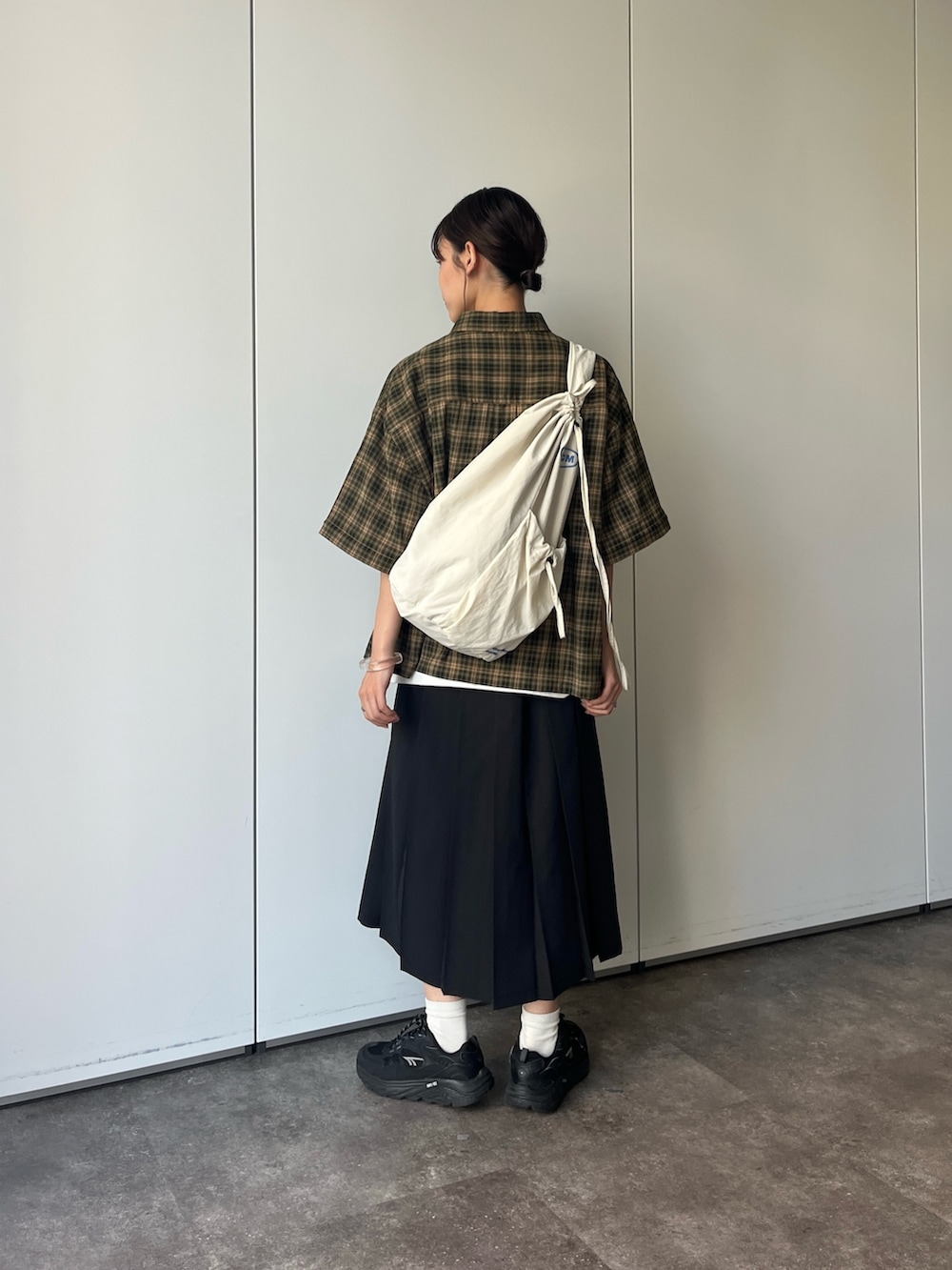 グリーン系のシャツ/ブラウス、ブラック系のスカートを着用したレディースの夏コーディネートの2枚目の写真