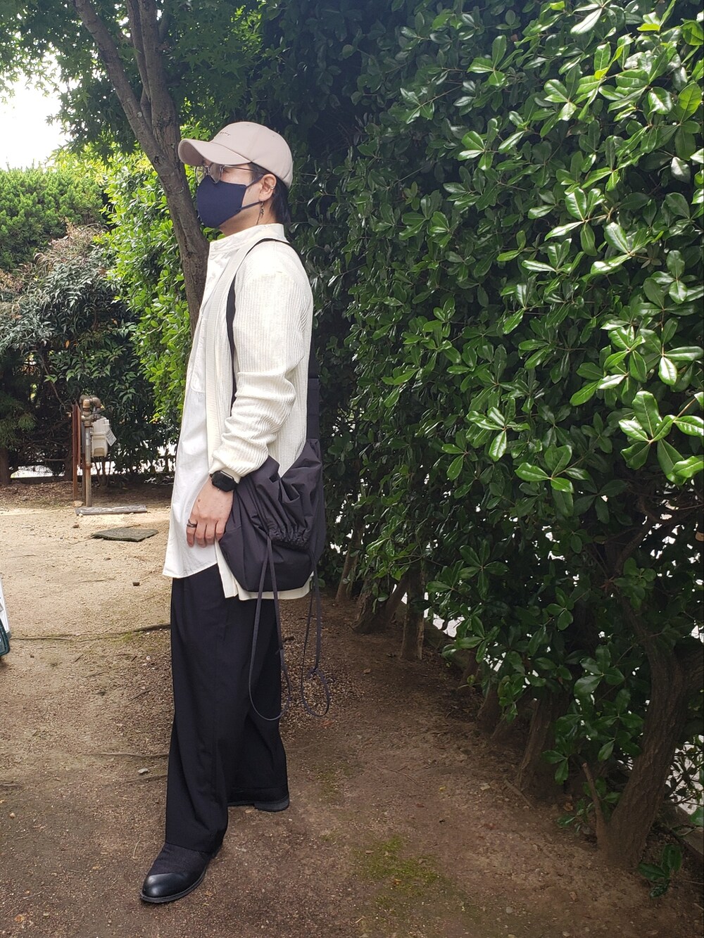 ホワイト系のニット/セーター、ブラック系のスラックス、ホワイト系のシャツ/ブラウスを着用したメンズの春コーディネートの2枚目の写真