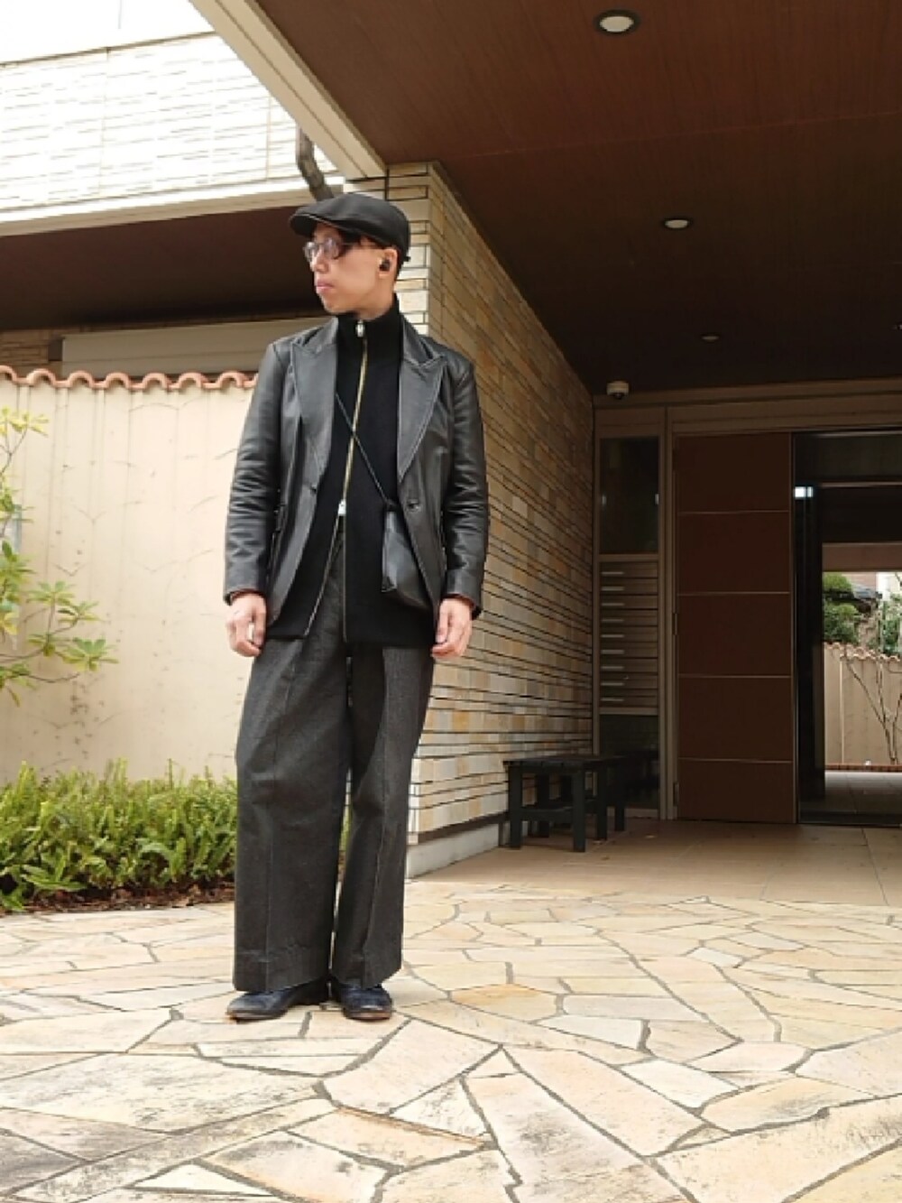 ブラック系のデニムパンツ、ブラック系のベスト、ブラック系のテーラードジャケットを着用したメンズの冬コーディネートの2枚目の写真