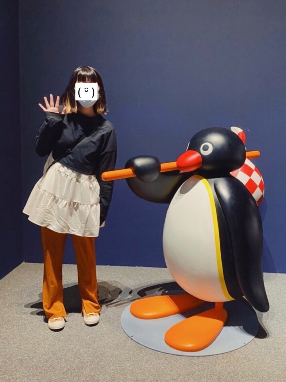 ブラック系のトップス、ホワイト系のシャツ/ブラウス、オレンジ系のスラックスを着用したレディースの冬コーディネートの2枚目の写真