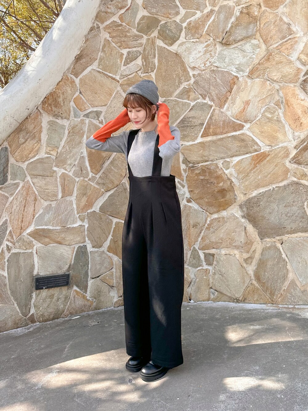 ブラック系のブーツ、ブラック系のサロペット/オーバーオール、グレー系のニット/セーターを着用したレディースの冬コーディネートの3枚目の写真