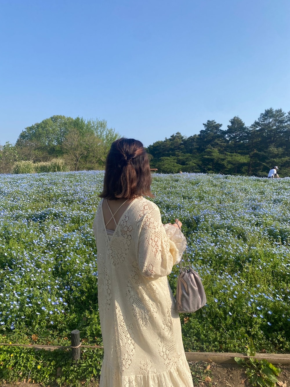 ホワイト系のワンピース、シルバー系のショルダーバッグ、ベージュ系のサンダルを着用したレディースの春コーディネートの2枚目の写真