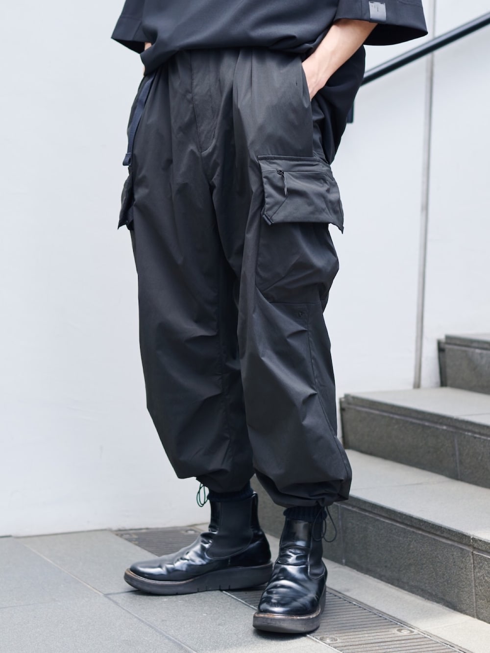 ブラック系のカーゴパンツ、ブラック系のブーツを着用したメンズの夏コーディネートの2枚目の写真