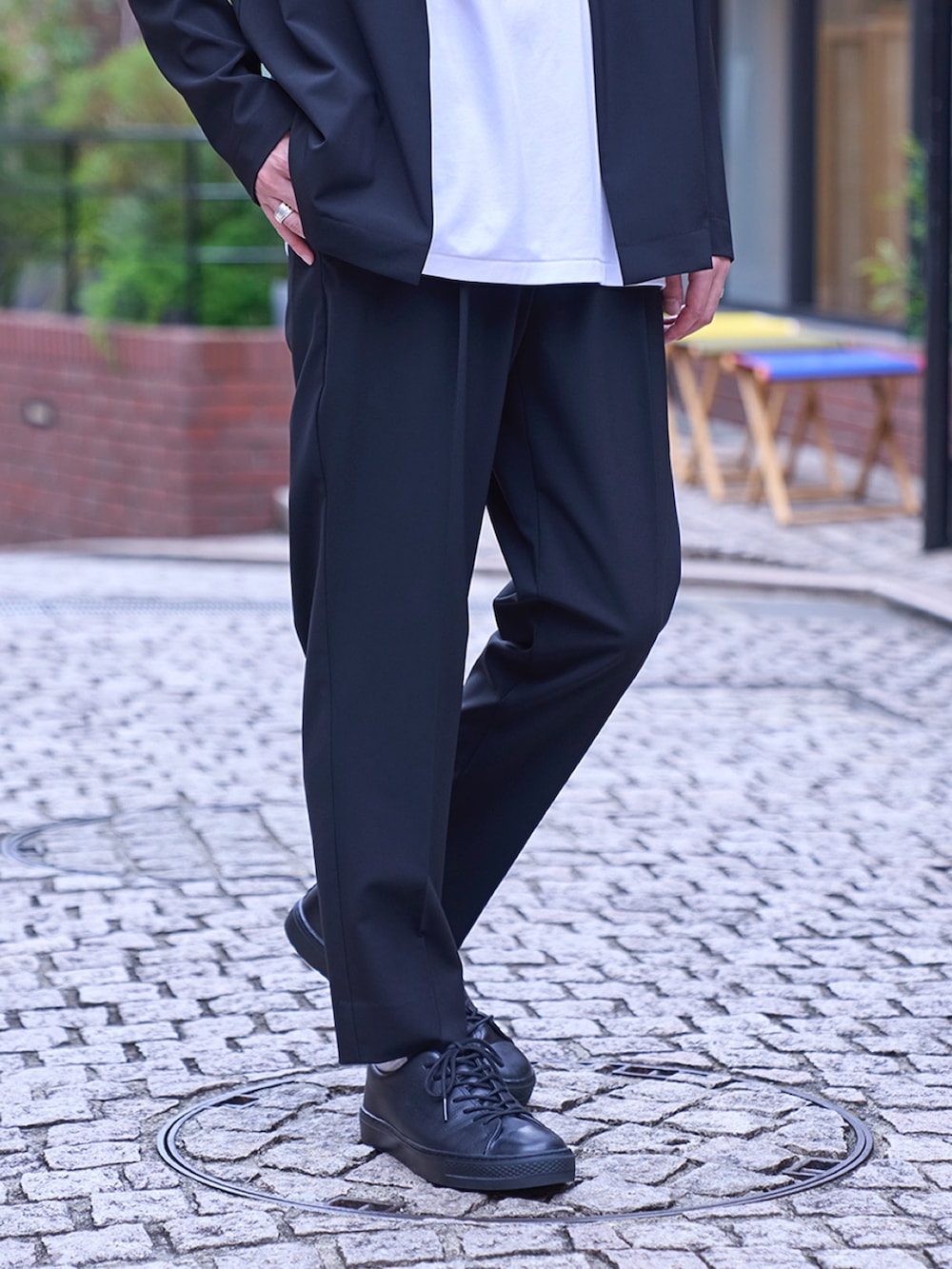 ブラック系のノーカラージャケット、ブラック系のスラックスを着用したメンズの夏コーディネートの2枚目の写真