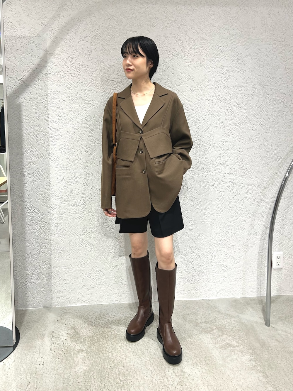 ブラウン系のその他アウター、ブラック系のその他パンツ、ブラウン系のブーツを着用したレディースの秋コーディネートの4枚目の写真