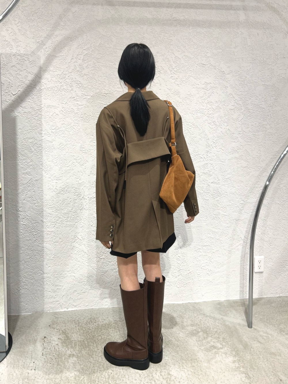 ブラウン系のその他アウター、ブラック系のその他パンツ、ブラウン系のブーツを着用したレディースの秋コーディネートの3枚目の写真