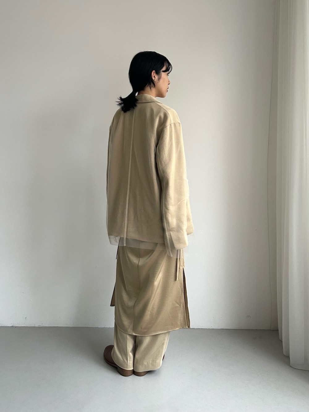 ベージュ系のその他アウター、ベージュ系のワンピース、ベージュ系のその他パンツを着用したレディースの秋コーディネートの3枚目の写真