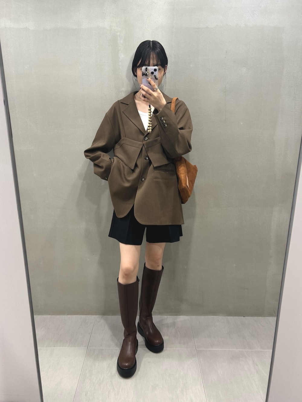 ブラウン系のその他アウター、ブラック系のその他パンツ、ブラウン系のブーツを着用したレディースの秋コーディネートの5枚目の写真