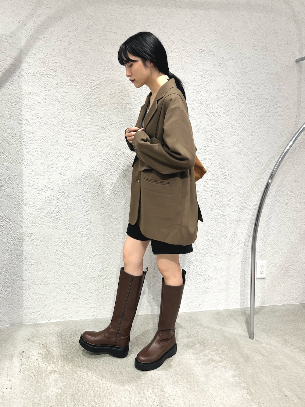 ブラウン系のその他アウター、ブラック系のその他パンツ、ブラウン系のブーツを着用したレディースの秋コーディネートの2枚目の写真