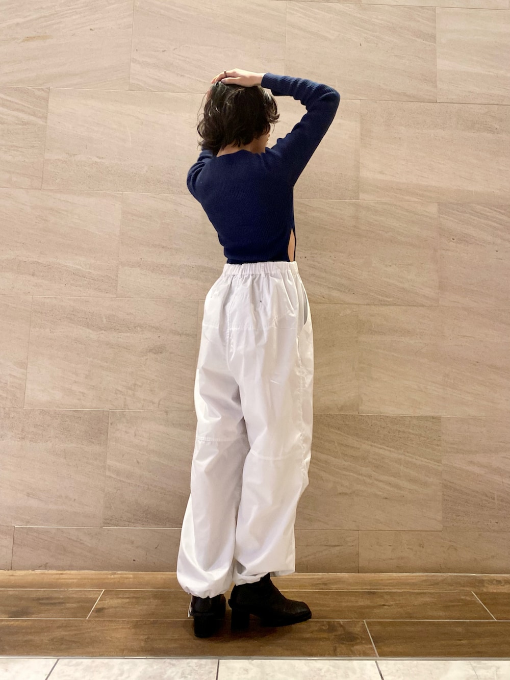 ブルー系のニット/セーター、ホワイト系のその他パンツ、ブラック系のブーツを着用したレディースの冬コーディネートの3枚目の写真