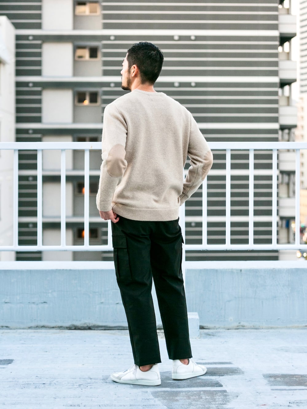 ベージュ系のニット/セーター、グレー系のカーゴパンツ、ホワイト系のスニーカーを着用したメンズの冬コーディネートの2枚目の写真