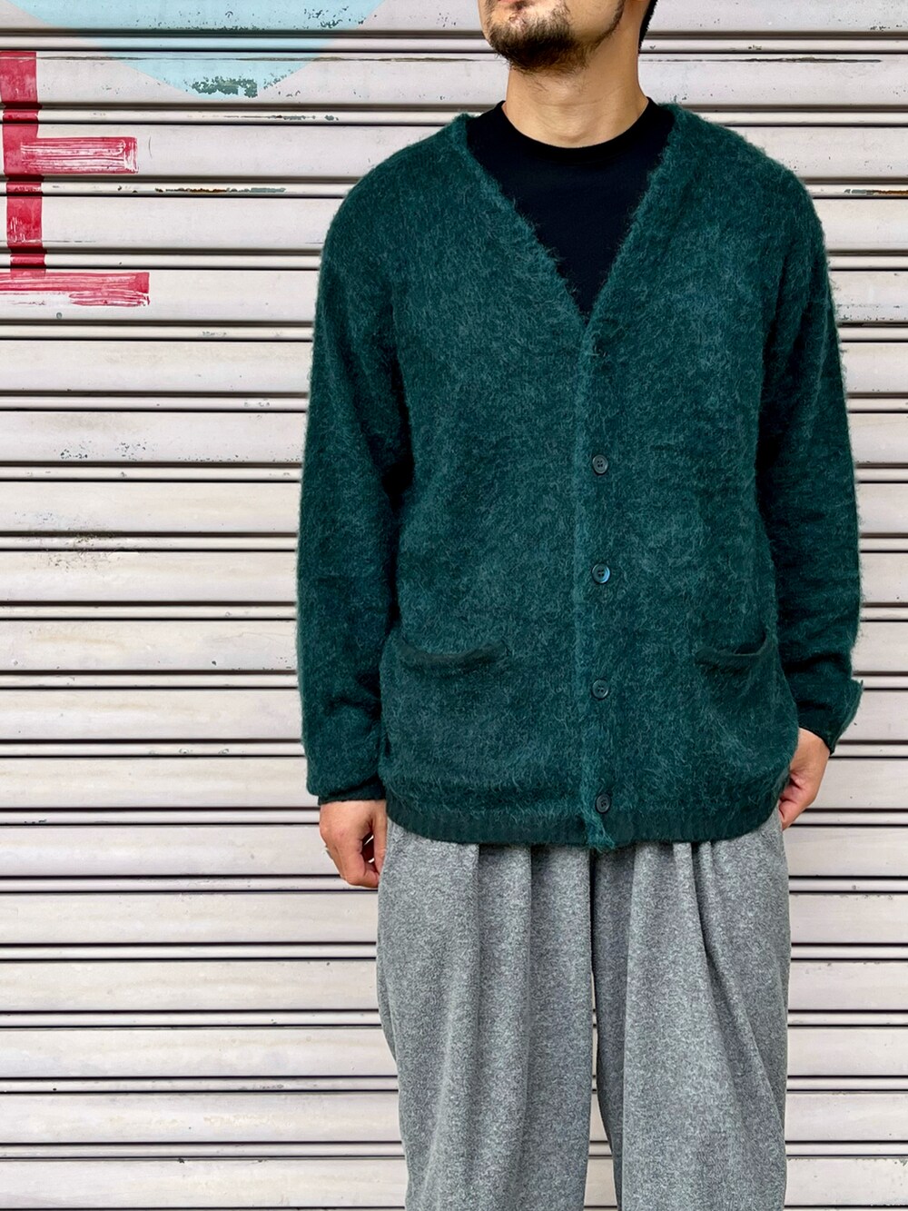ブラック系のニット/セーター、グリーン系のカーディガン/ボレロ、グレー系のパンツを着用したメンズの秋コーディネートの3枚目の写真
