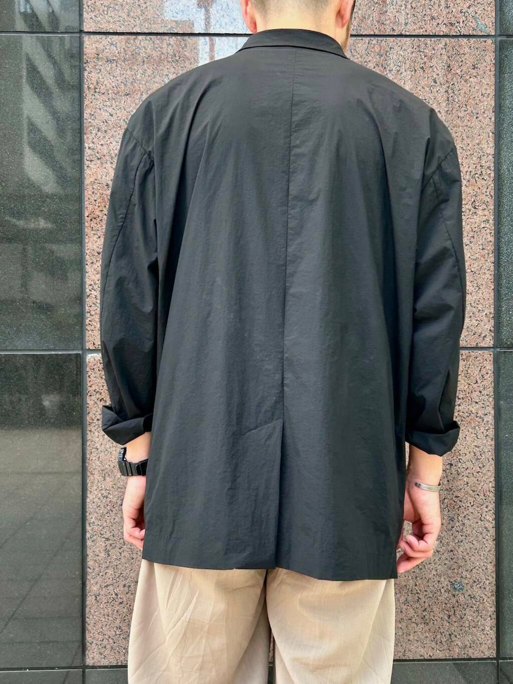 ブラック系のサンダル、ブラック系のその他アウター、ホワイト系のTシャツ/カットソーを着用したメンズの夏コーディネートの4枚目の写真