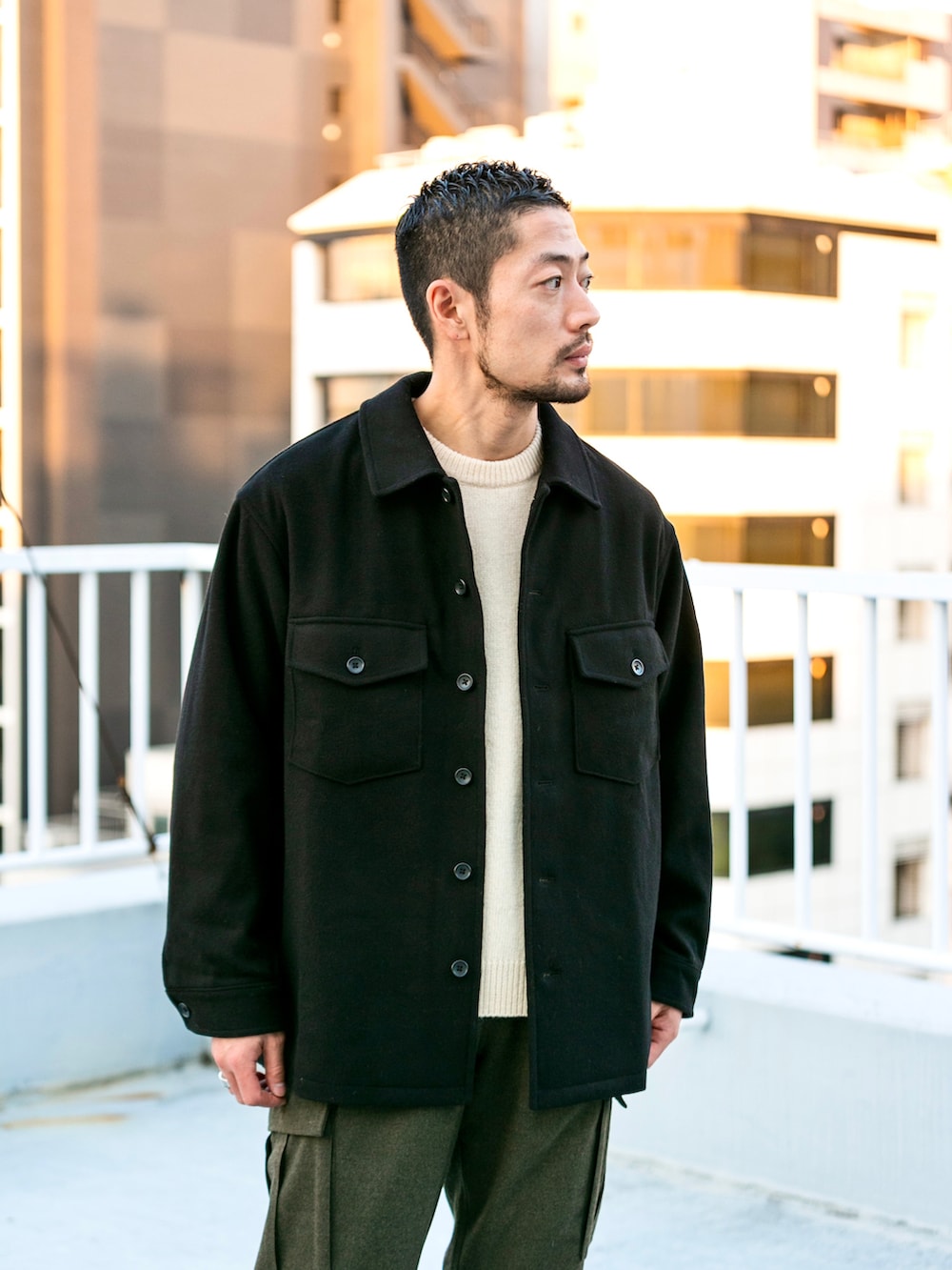 グリーン系のカーゴパンツ、ブラック系のその他アウター、ベージュ系のニット/セーターを着用したメンズの冬コーディネートの3枚目の写真