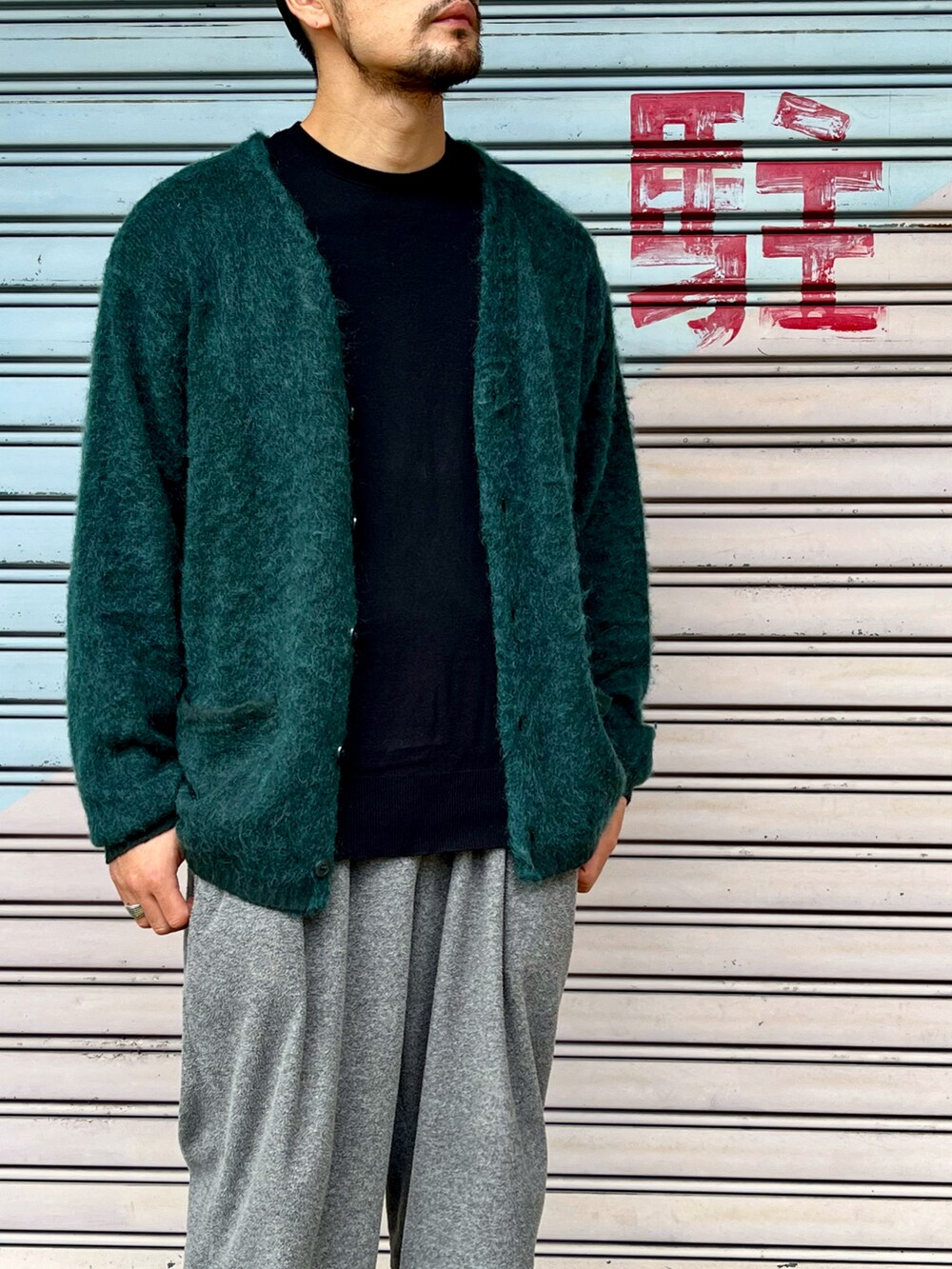 ブラック系のニット/セーター、グリーン系のカーディガン/ボレロ、グレー系のパンツを着用したメンズの秋コーディネートの2枚目の写真