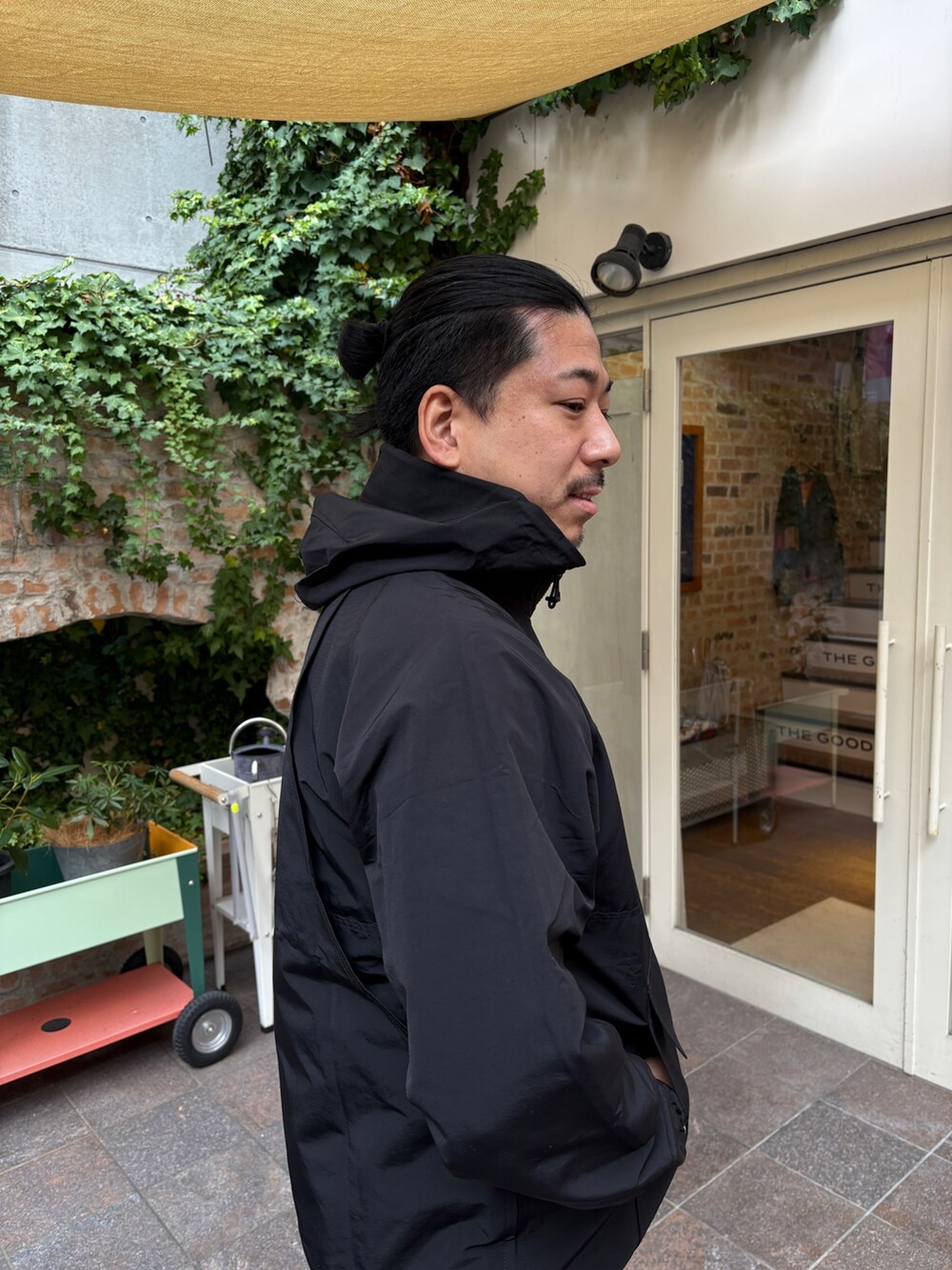 ブラック系のマウンテンパーカー、ホワイト系のその他パンツ、ブラック系のサンダルを着用したメンズの冬コーディネートの3枚目の写真