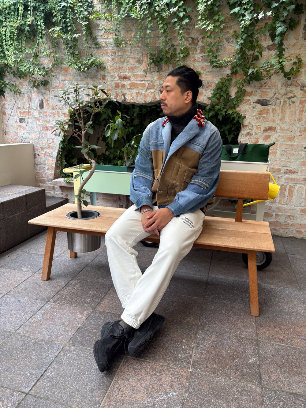 ブルー系のデニムジャケット、ブラック系のニット/セーター、ホワイト系のその他パンツを着用したメンズの秋コーディネートの3枚目の写真