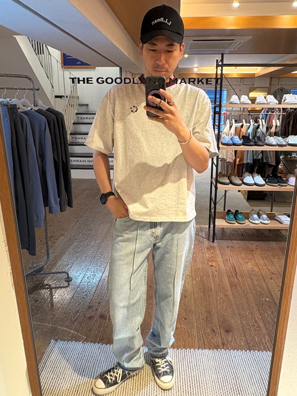 レッド系のトートバッグ、その他のデニムパンツ、ベージュ系のTシャツ/カットソーを着用したメンズの夏コーディネートの5枚目の写真