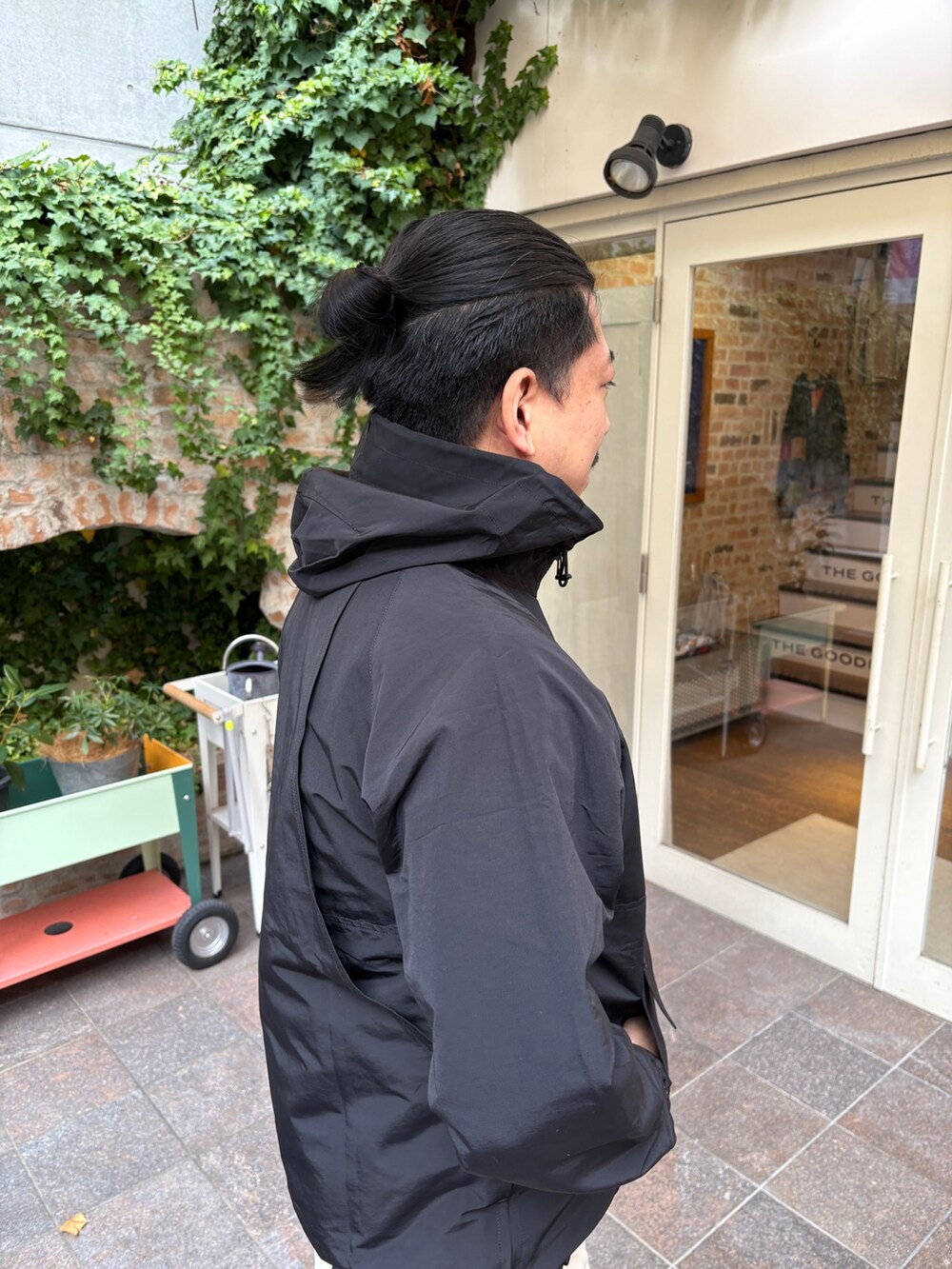 ブラック系のマウンテンパーカー、ホワイト系のその他パンツ、ブラック系のサンダルを着用したメンズの冬コーディネートの2枚目の写真