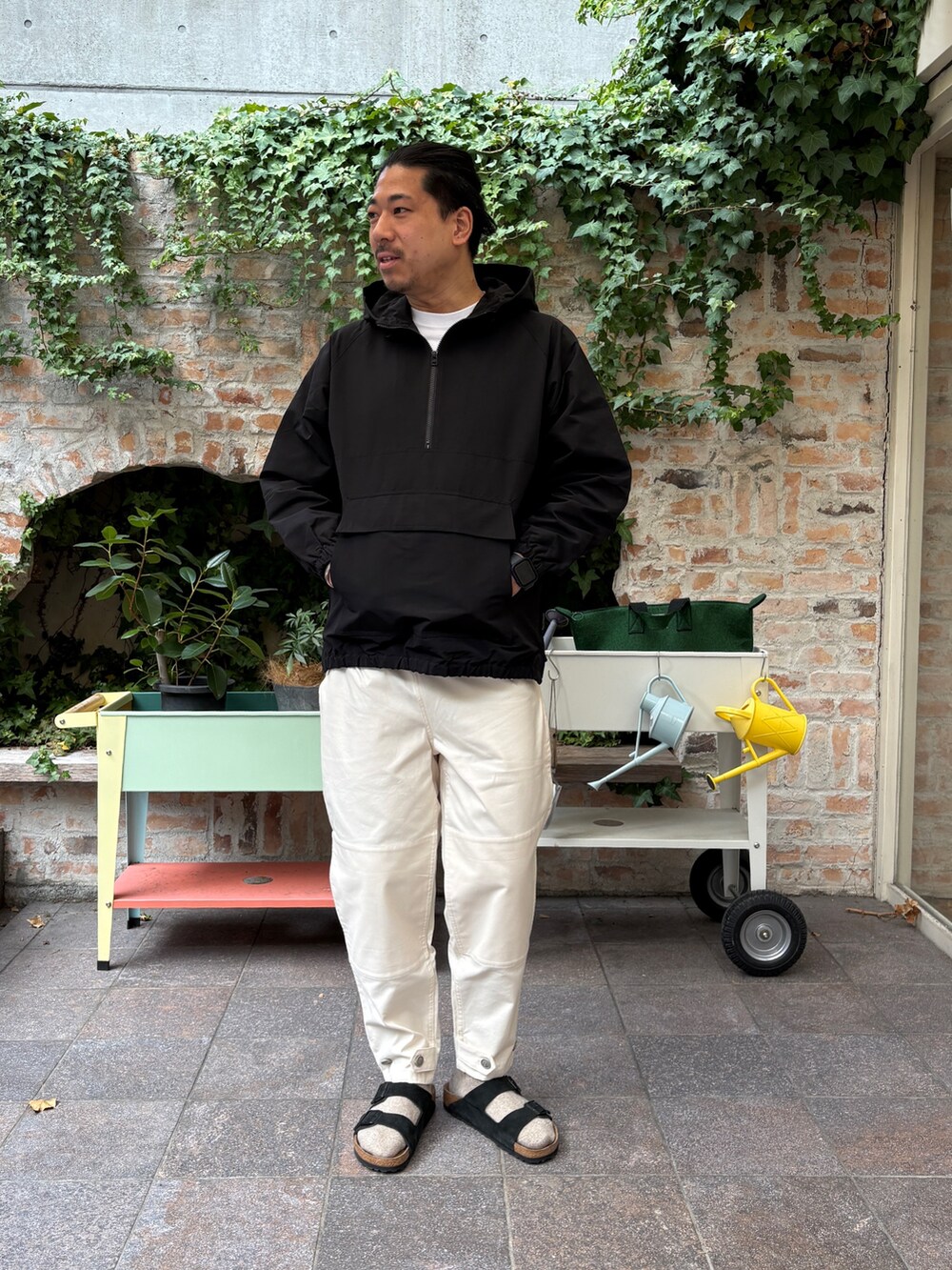 ブラック系のマウンテンパーカー、ホワイト系のその他パンツ、ブラック系のサンダルを着用したメンズの冬コーディネートの6枚目の写真