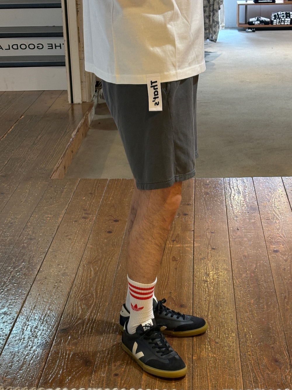 ホワイト系のTシャツ/カットソー、グレー系のその他パンツ、ブラック系のスニーカーを着用したメンズの夏コーディネートの4枚目の写真