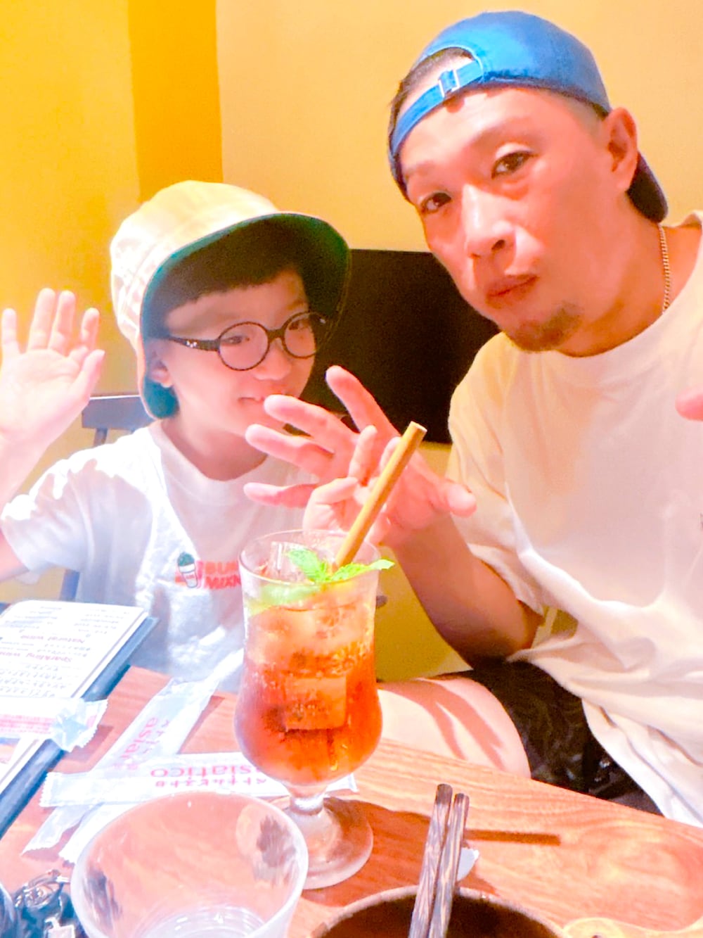 ホワイト系のTシャツ/カットソー、ブラック系のパンツ、ブルー系のスニーカーを着用したメンズの夏コーディネートの3枚目の写真