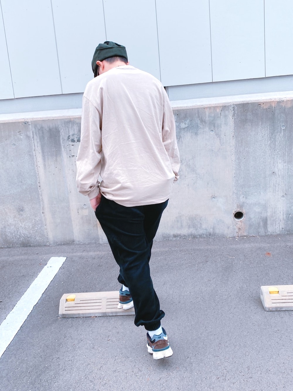 ベージュ系のTシャツ/カットソー、ブラック系のパンツ、ブラック系のスニーカーを着用したメンズの秋コーディネートの3枚目の写真