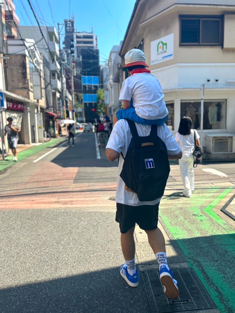 ホワイト系のTシャツ/カットソー、ブラック系のパンツ、ブルー系のスニーカーを着用したメンズの夏コーディネートの2枚目の写真