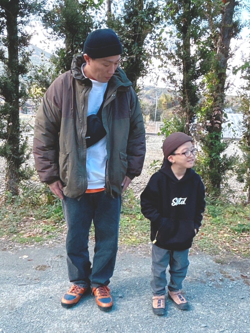 ブラック系のショルダーバッグ、ブラウン系のその他アウター、ブラック系のデニムパンツを着用したメンズの冬コーディネートの3枚目の写真