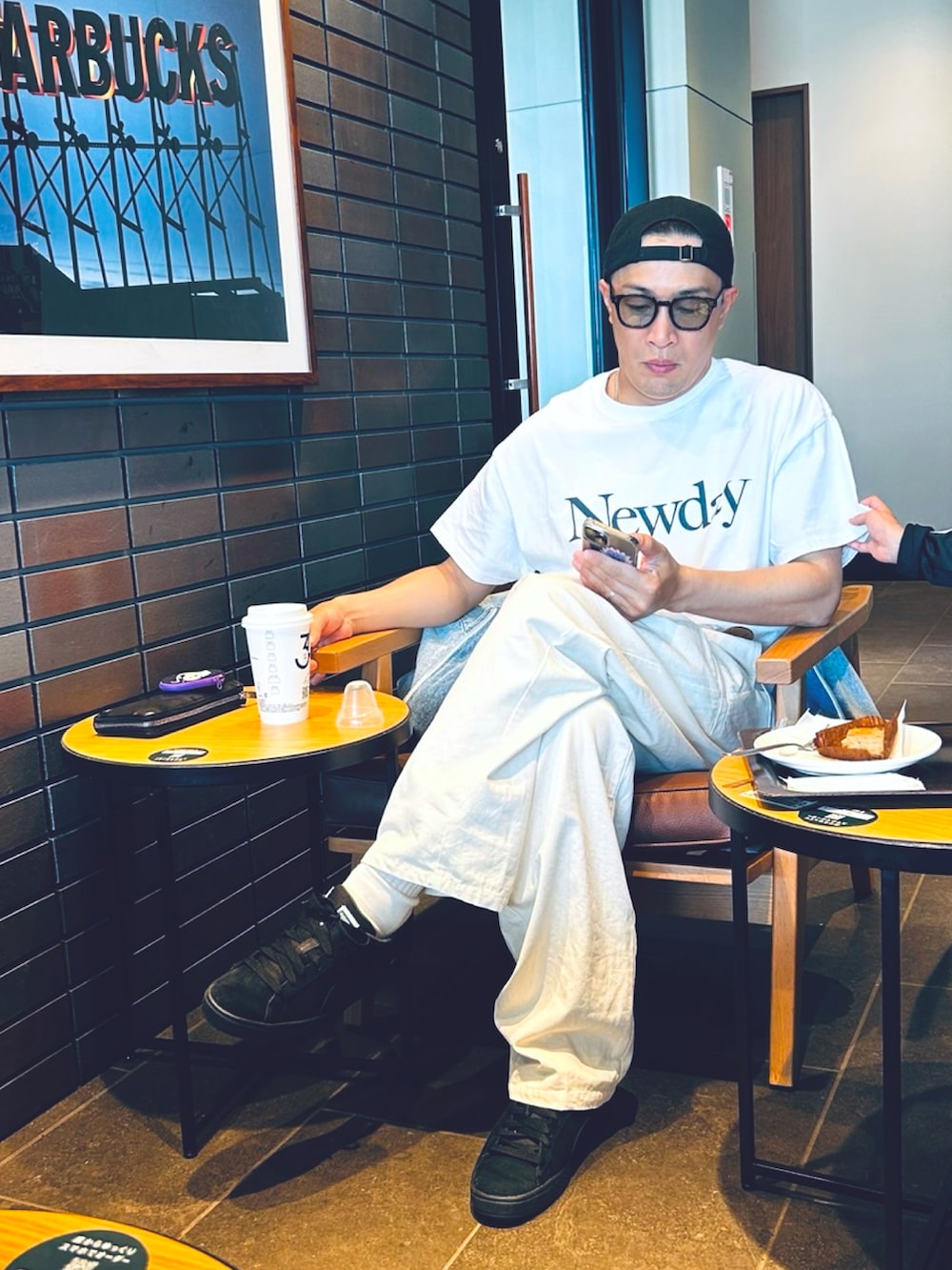 ホワイト系のチノパンツ、ブラック系のスニーカー、ブルー系のデニムジャケットを着用したメンズの春コーディネートの4枚目の写真