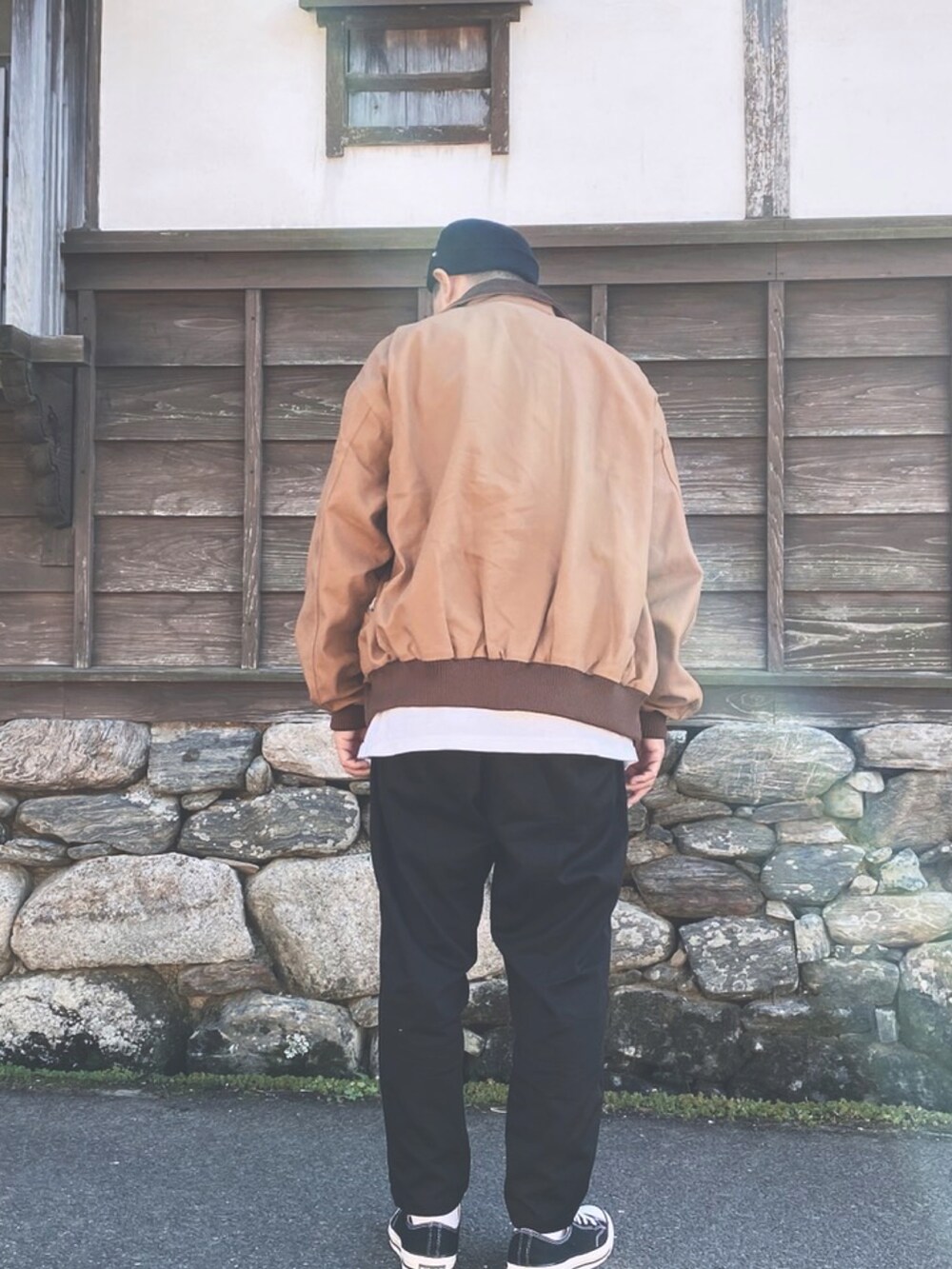 ブラウン系のジャケット/アウター、ホワイト系のTシャツ/カットソー、ブラック系のチノパンツを着用したメンズの秋コーディネートの4枚目の写真