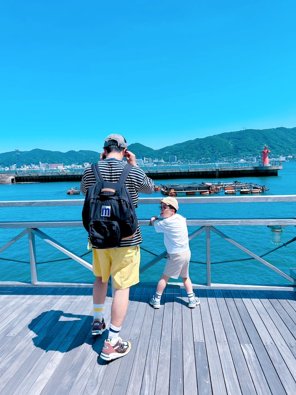 ブルー系のTシャツ/カットソー、イエロー系のその他パンツ、ブラウン系のスニーカーを着用したメンズの夏コーディネートの4枚目の写真