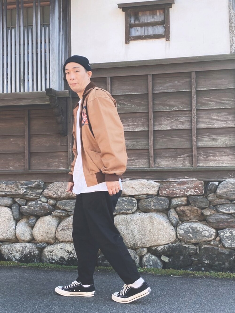 ブラウン系のジャケット/アウター、ホワイト系のTシャツ/カットソー、ブラック系のチノパンツを着用したメンズの秋コーディネートの2枚目の写真