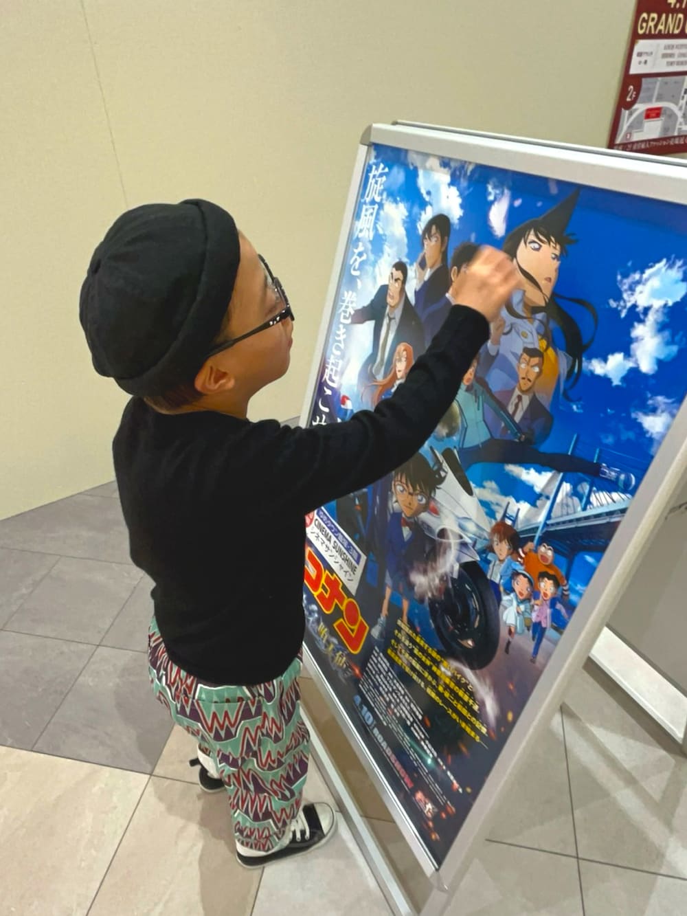 レッド系のブルゾン、ホワイト系のチノパンツ、ブラウン系のスニーカーを着用したメンズの春コーディネートの5枚目の写真