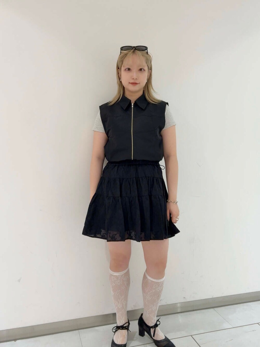 ブラック系のベスト、ブラック系のパンプス、ブラック系のスカートを着用したレディースの夏コーディネートの2枚目の写真