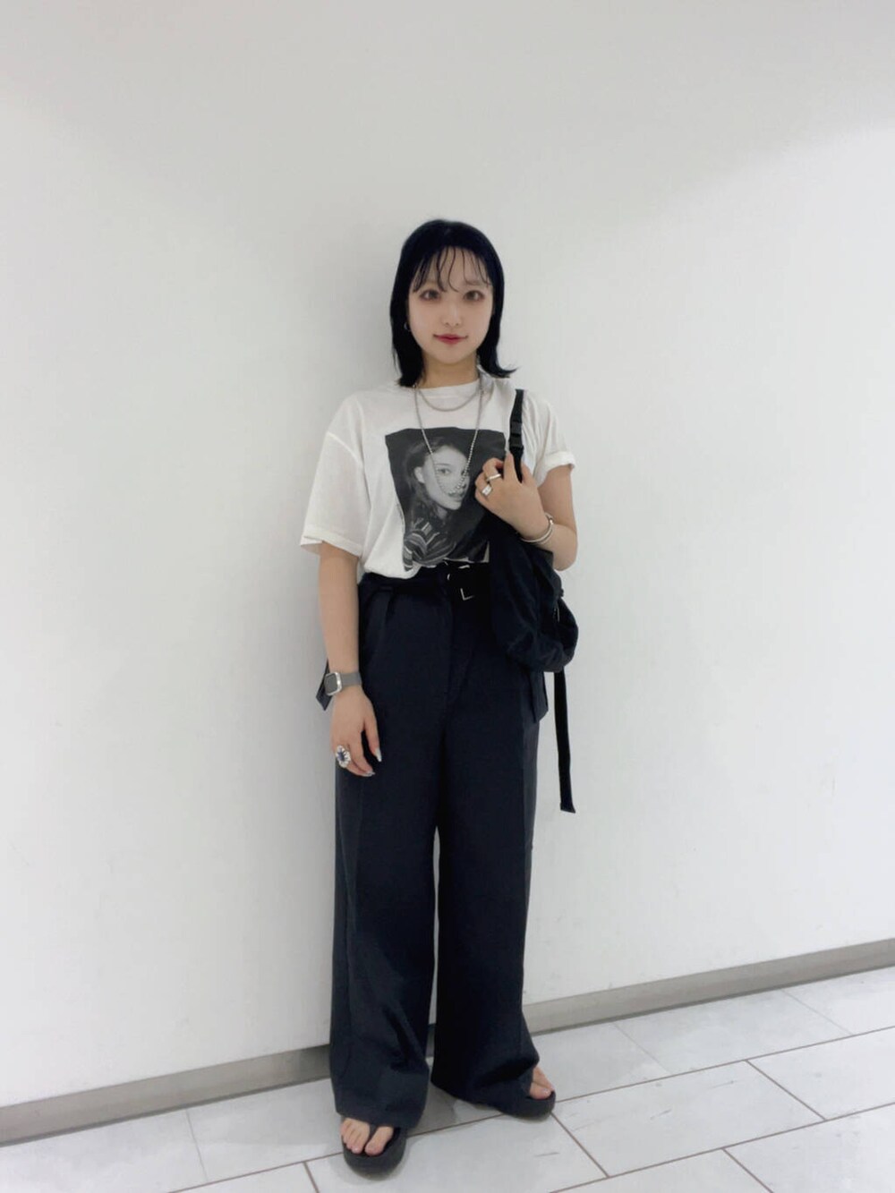 グレー系のチノパンツ、グレー系のスカート、ブラック系のショルダーバッグを着用したレディースの夏コーディネートの2枚目の写真