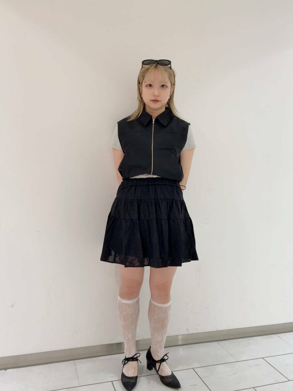 ブラック系のベスト、ブラック系のパンプス、ブラック系のスカートを着用したレディースの夏コーディネートの3枚目の写真