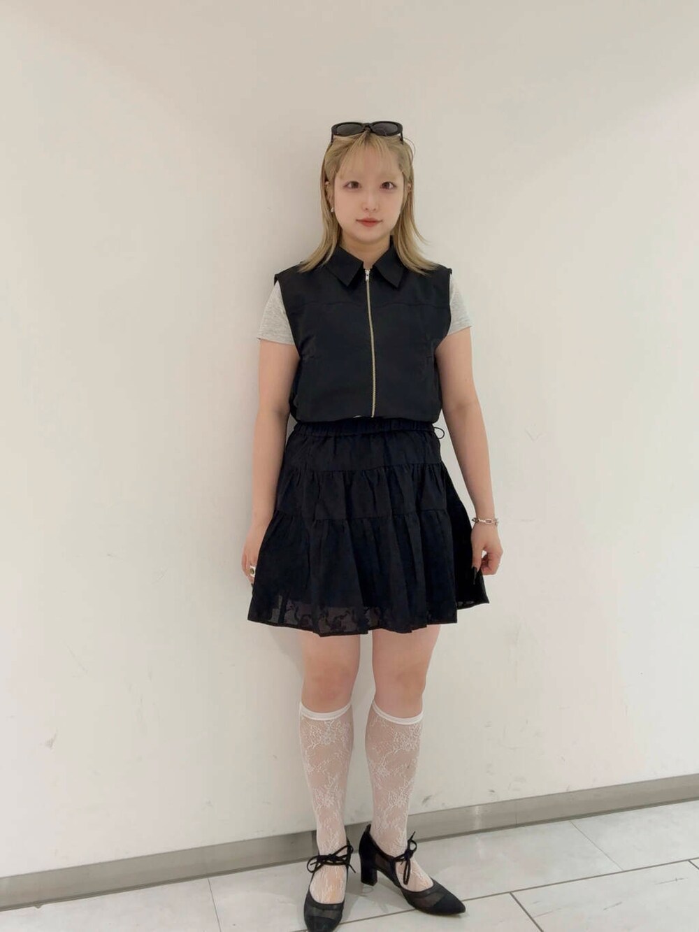 ブラック系のベスト、ブラック系のパンプス、ブラック系のスカートを着用したレディースの夏コーディネートの4枚目の写真