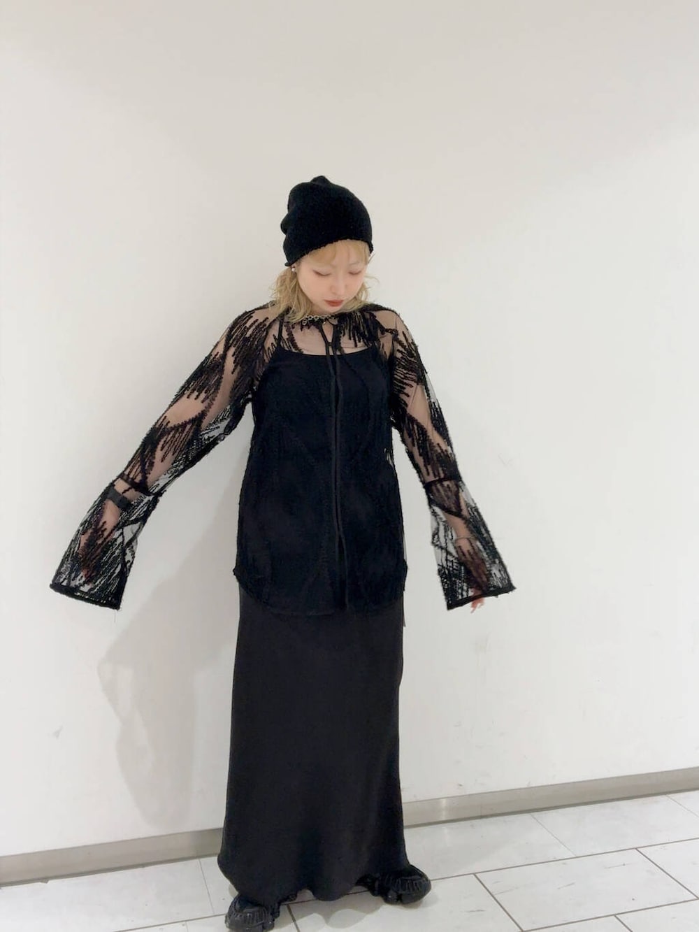 ホワイト系のショルダーバッグ、ブラック系のスカート、ブラック系のシャツ/ブラウスを着用したレディースの春コーディネートの2枚目の写真