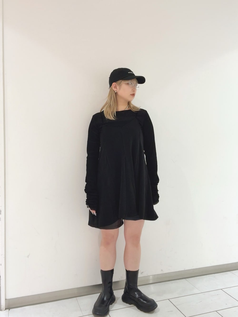 ブラック系のワンピース、ブラック系のTシャツ/カットソー、ブラック系のブーツを着用したレディースの秋コーディネートの2枚目の写真