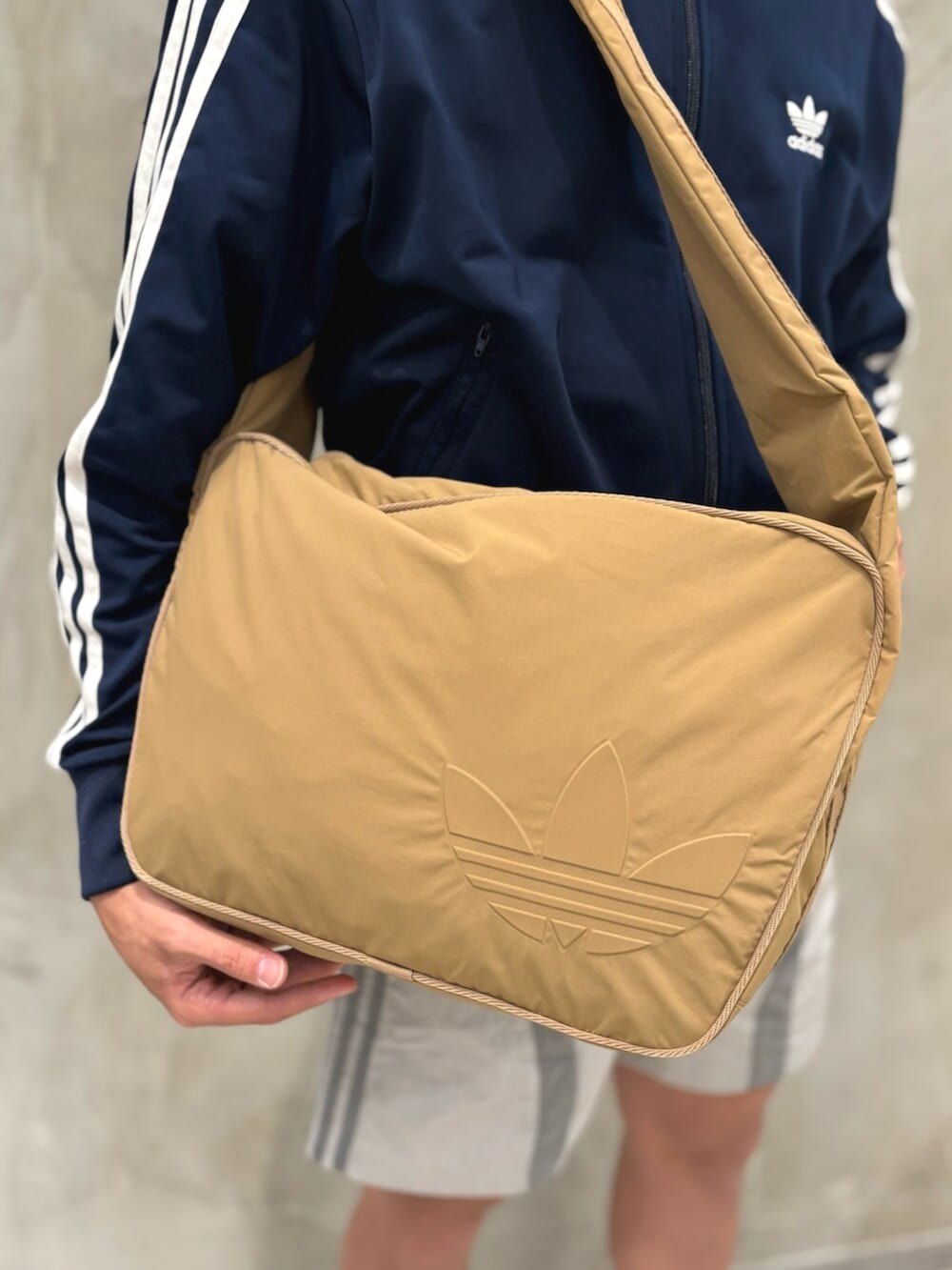 ホワイト系のスニーカー、グレー系のその他パンツ、ブラウン系のショルダーバッグを着用したメンズの夏コーディネートの4枚目の写真
