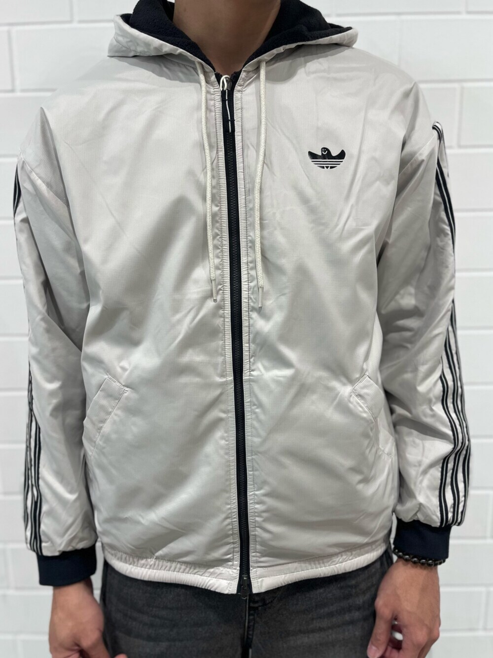 ブラック系のジャケット/アウター、ベージュ系のブルゾン、ブラック系のスニーカーを着用したメンズの秋コーディネートの4枚目の写真